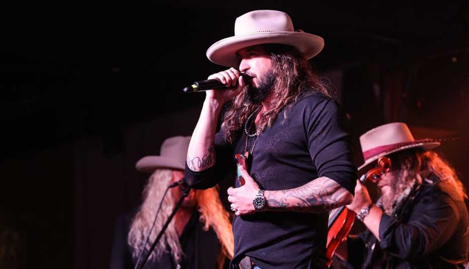 War Hippies founders Scott 'Scooter' Brown and Donnie Reis first met during the pandemic. scooter brown of the war hippies sings into a microphone on stage