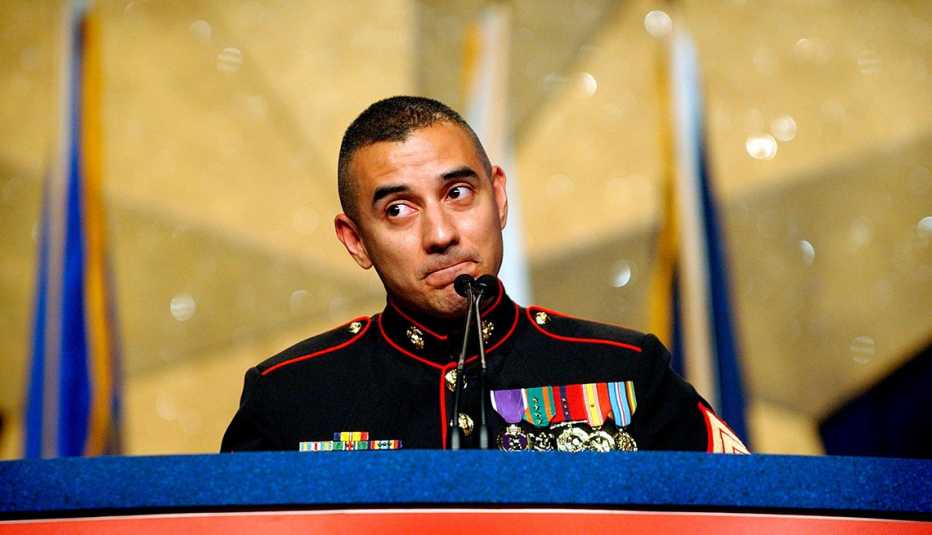 Eric Alva, in his marine dress uniform, speaks at a podium