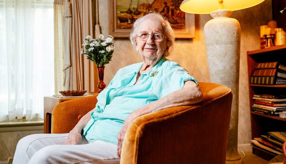 Betty Sharrer poses for a portrait in front one of the many paintings she has made my German POWs during WWII. Betty and her husband, Bob, ran a POW camp in Texas for the US military during the war. CREDIT: Nick Hagen for AARP Bulletin