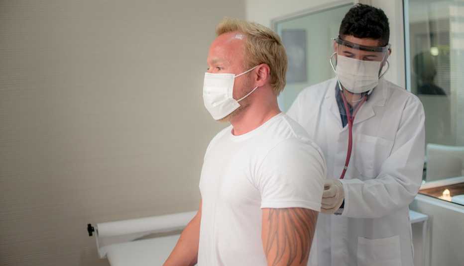 middle aged man being examined by a doctor with a stethoscope
