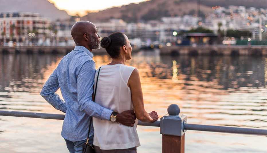 A man and woman look out onto the water