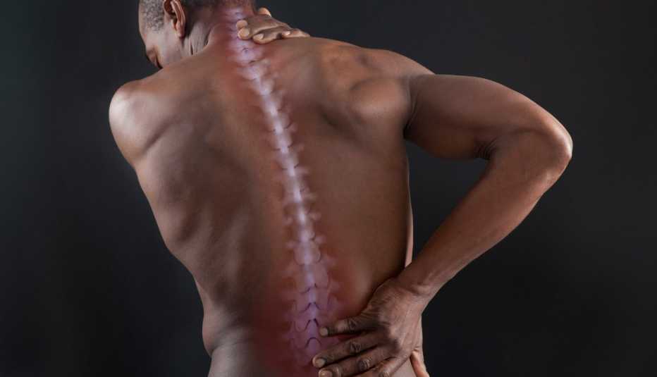 a man with his hand on his lower back cause he is in pain