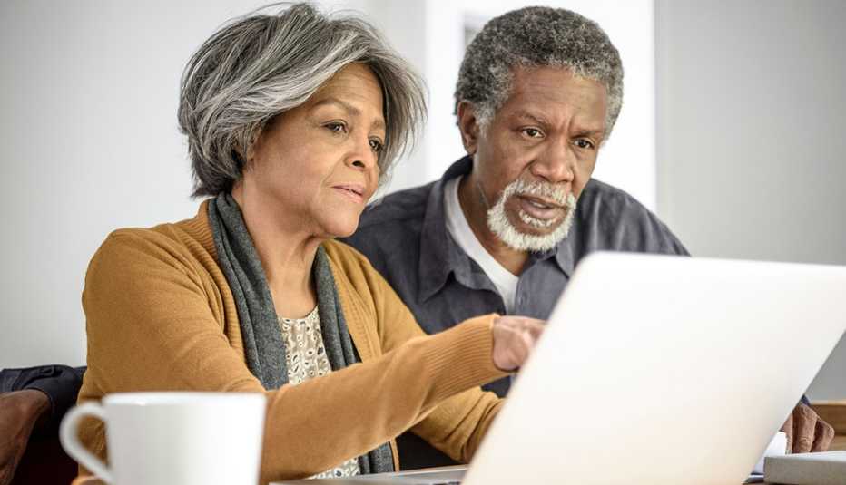An older couple looking at a computer screen An older couple looking at a computer screen