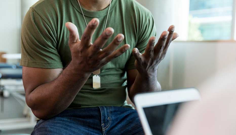 a military service member gestures in frustration in a doctors office
