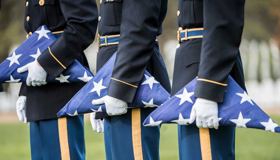 soldiers all holding folded up american flags