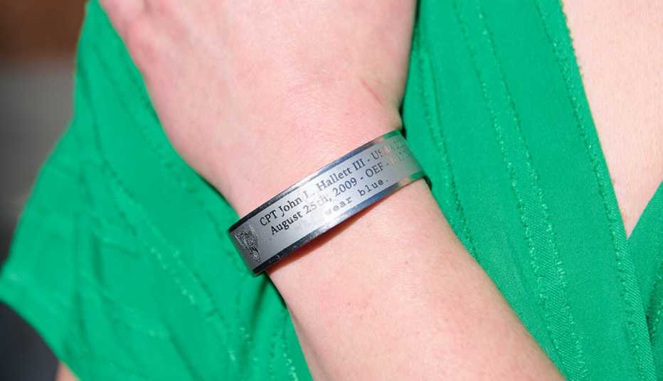 a braclet on an arm with a green shirt behind it