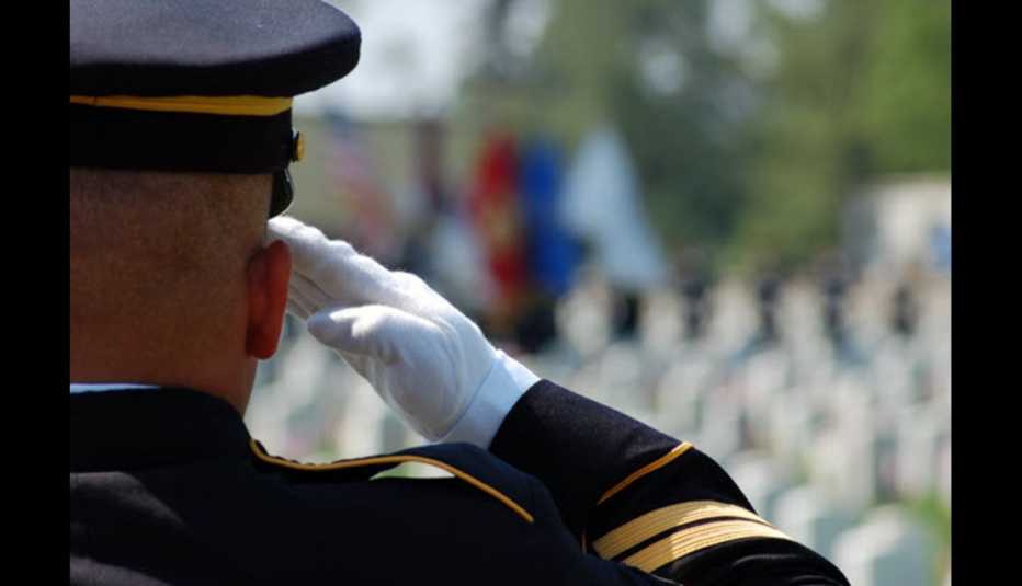 Army soldier renders salute at cemetery