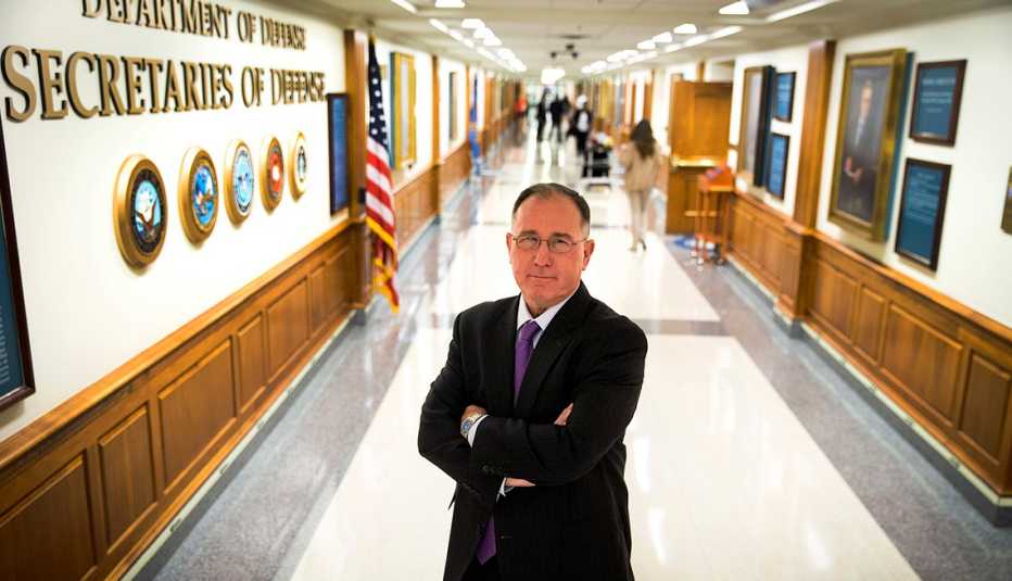 mike vickers poses in a hallway