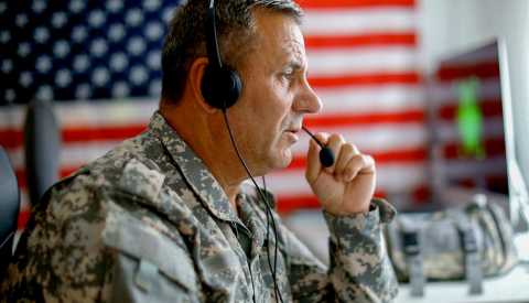 a man in military gear talks on a headset a man in military gear talks on a headset