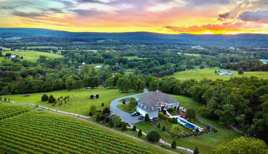 Veterans can get discounted rates at Hidden Views Bed and Breakfast. a bed and breakfast sits in the middle of green hills and trees at sunset