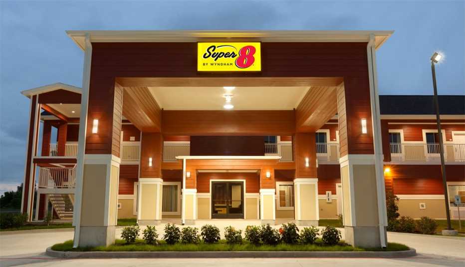 a super 8 by wyndham sign hangs above the entrance to a super 8 hotel.