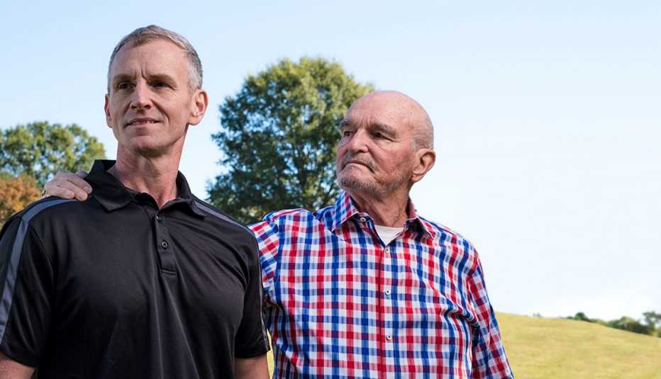 two men standing next to each other in a field