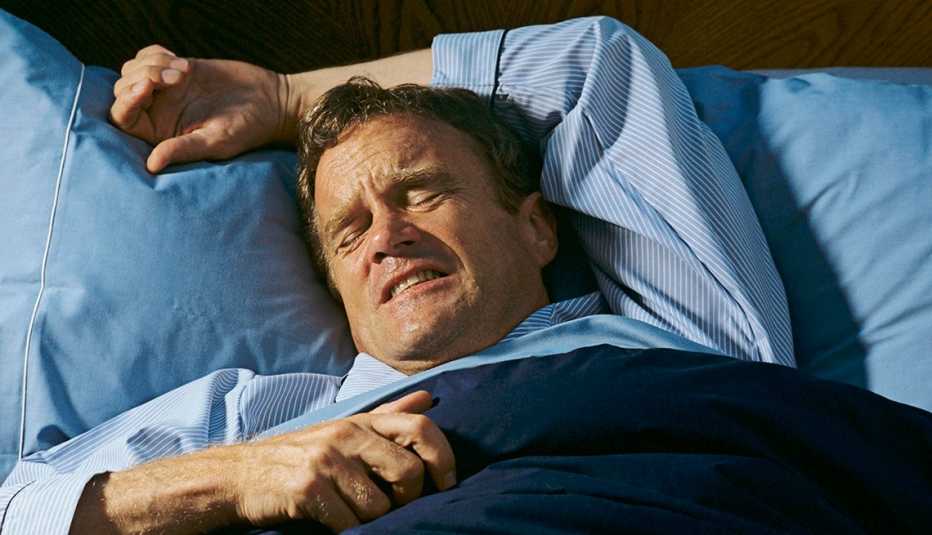 a man is struggling sleeping in a bed