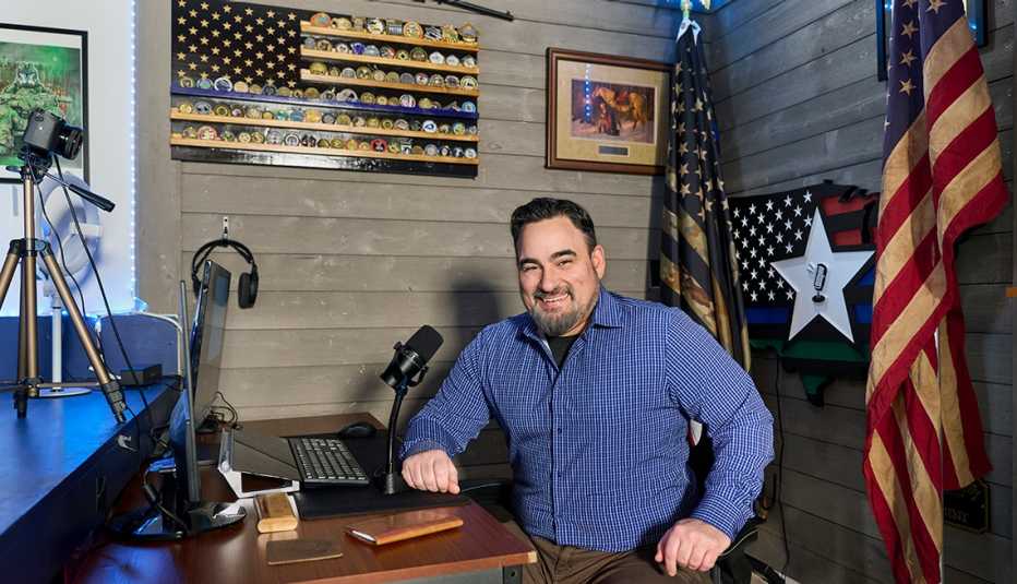 a podcaster sits at a desk