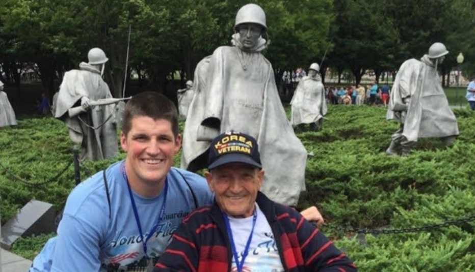 john ghizas, wearing a korea veteran hat, poses with grandson in law justin frost in front of the korean war veterans memorial