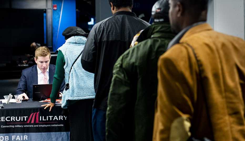 a group of people are waiting in line to talk with a recruiter at a job fair