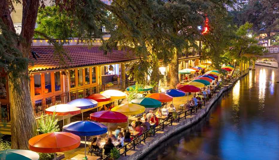colorful table umbrellas line the river walk in san antonio, texas