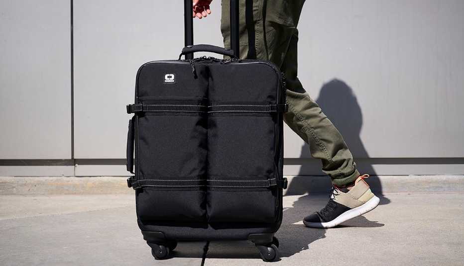 close up of a black ogio carry on bag being wheeled down a walkway