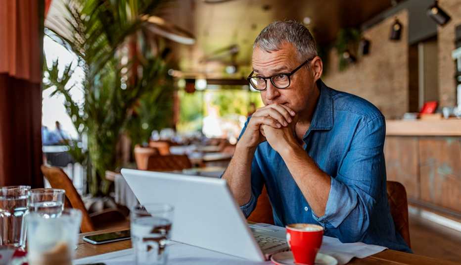 A man sitting at a table working on his computer