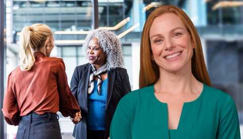 a woman standing in front of two women shaking hands