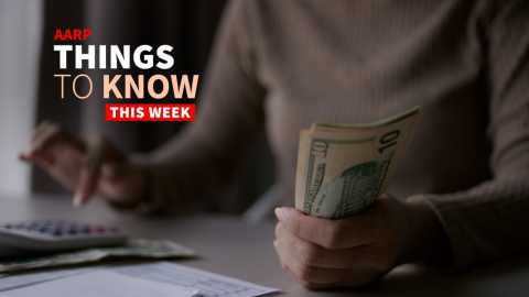 a photo shows a woman working a budget, using a calculator with one hand and cash in the other