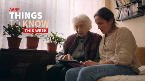 A photo shows an older adult woman and a younger woman on a couch using a tablet