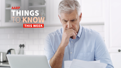 a man is shown in a photo looking at papers with his laptop nearby