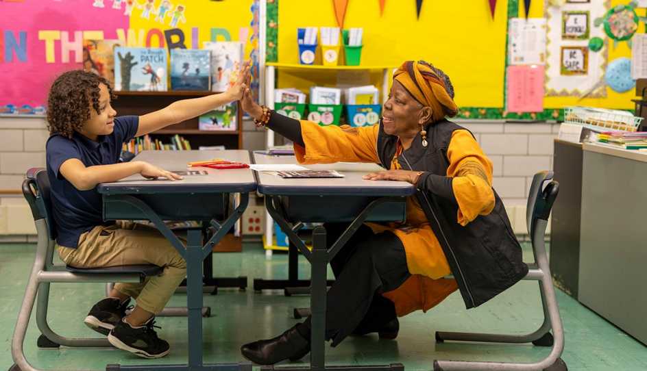 Woman reading to a child in a classroom