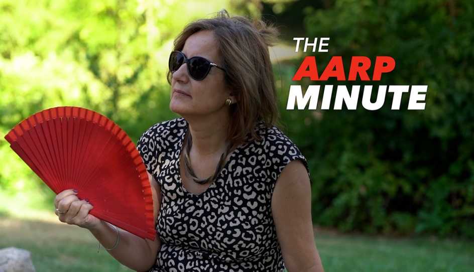 a woman wearing sunglasses fanning herself