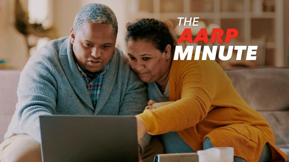 a couple sitting on a couch looking at a laptop computer