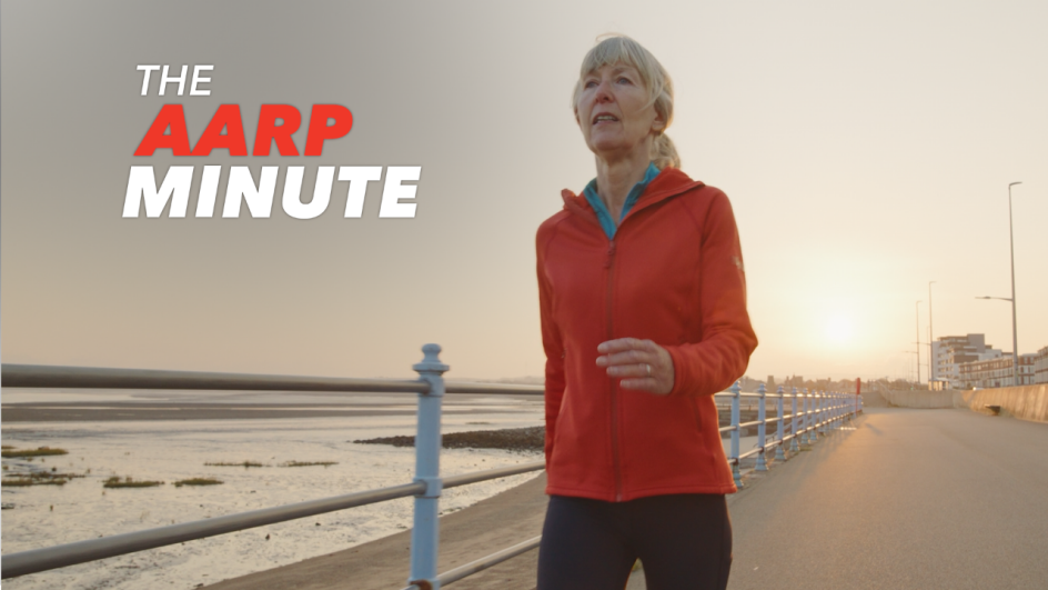 a woman walking on a boardwalk next to the ocean