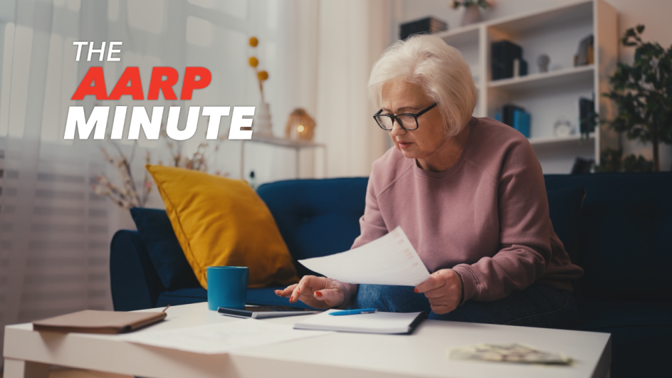 a woman sitting on a couch looking at paperwork and using a calculator