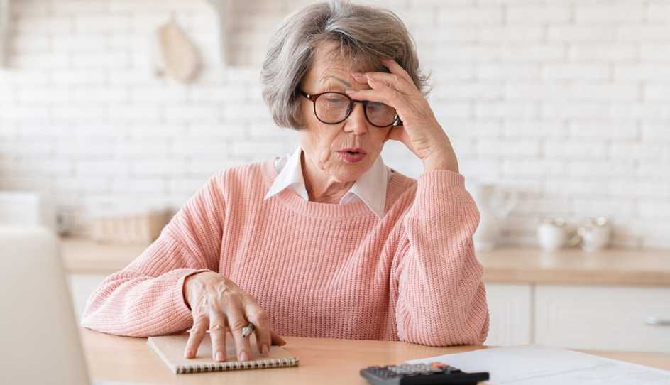 a woman looks frustrated while looking at a calculator