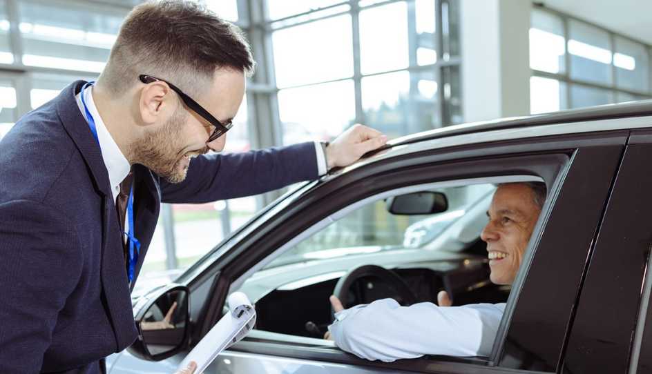 a person in a car talking with someone outside the car