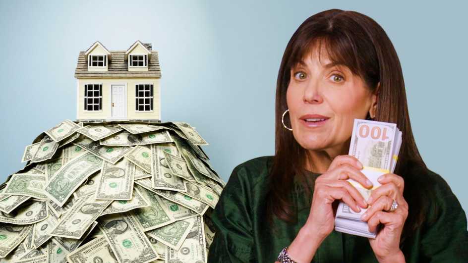 Jean Chatzky holds a stack of money next to a home balancing on a pile of cash