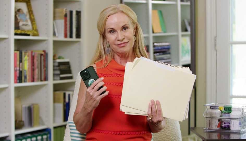 a woman holding files and a phone