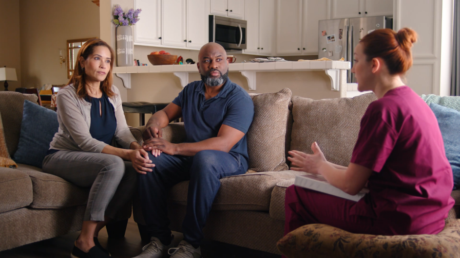 couple meeting with nurse on couch at home