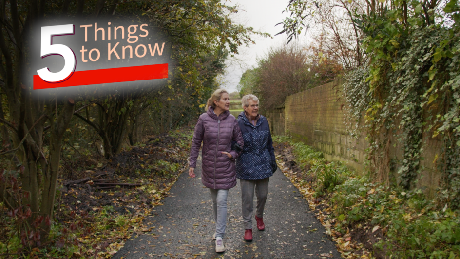 two women walking arm in arm down a path. five things to know