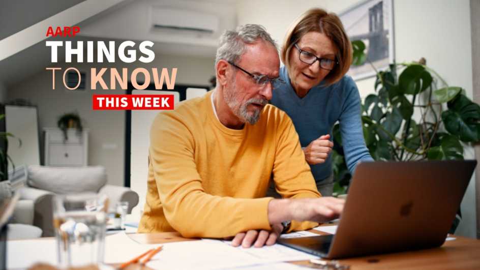 An older adult couple work on a laptop computer