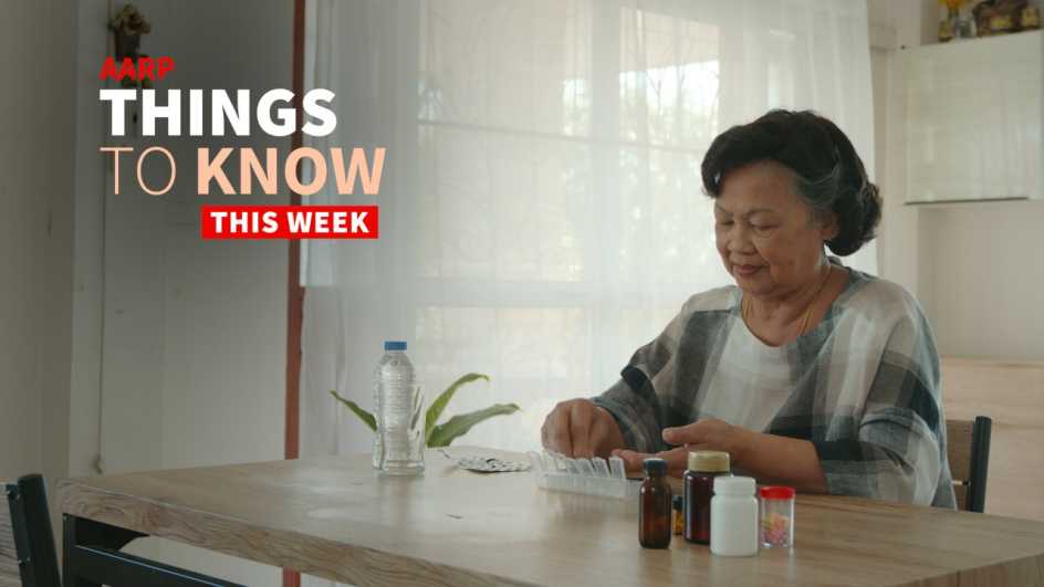 an older adult woman is shown sitting at table, parsing out her meds into a daily drug planner