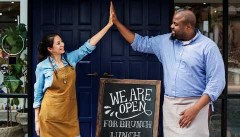 A man and a woman are giving each other a high five A man and a woman are giving each other a high five