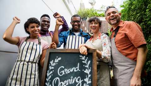a group of people celebrate the opening of their business