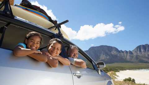 two kids hanging outside car window with grandfather in front seat looking out passenger window two kids hanging outside car window with grandfather in front seat looking out passenger window