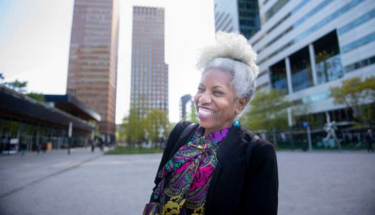 a woman smiles while walking in a city