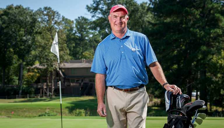 karl yergey posing on a green with golf clubs