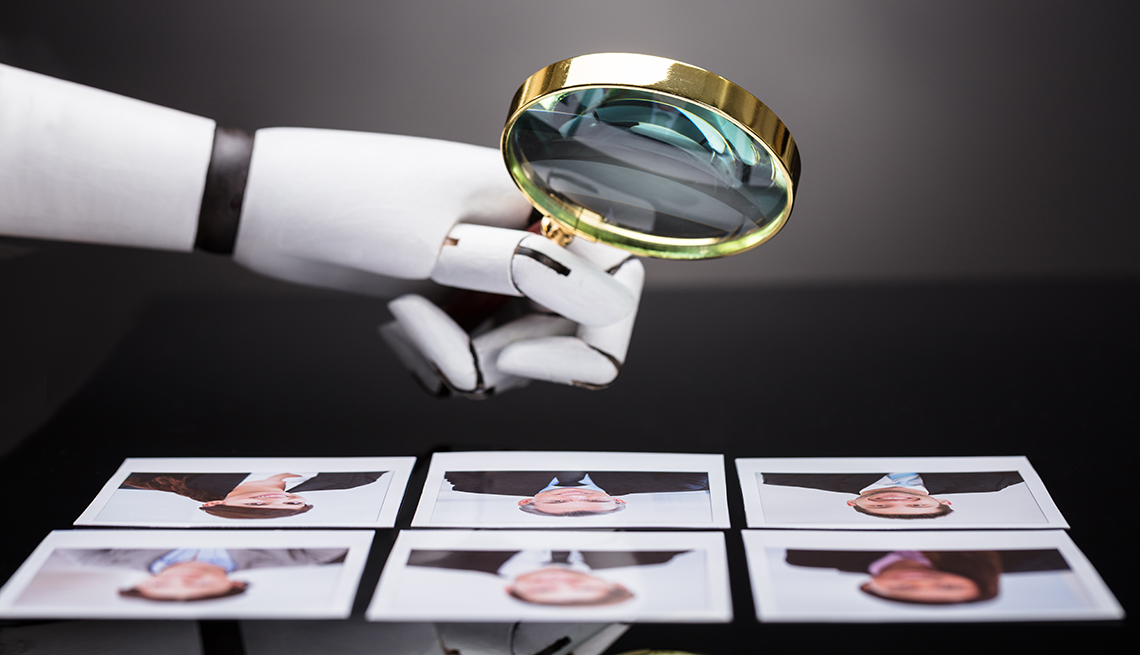 A robot hand looking over images of job applicants