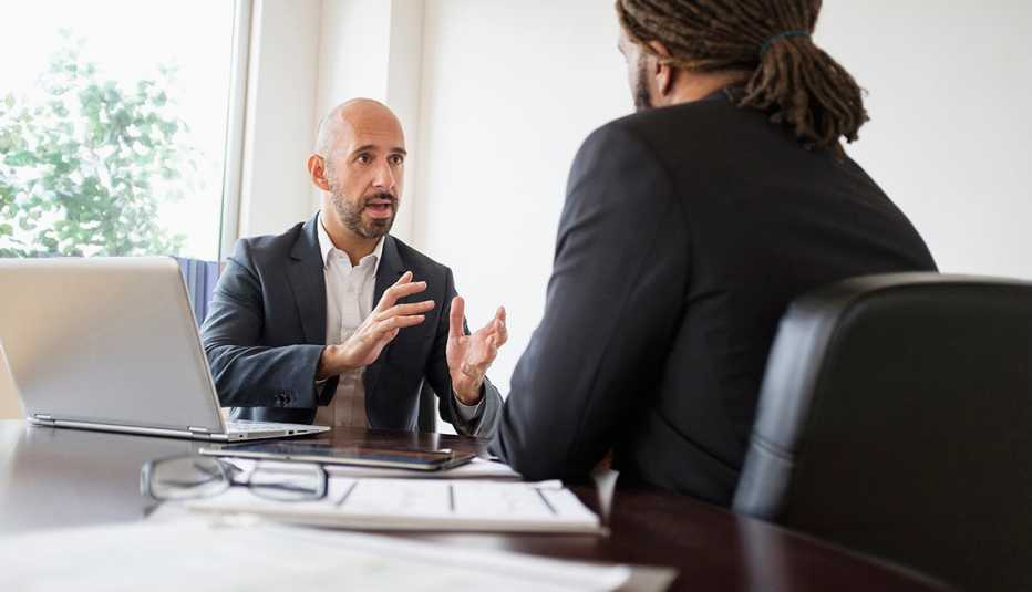 two men sitting at a table talking