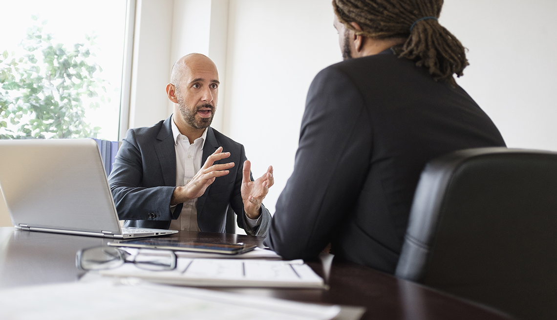 two men sitting at a table talking