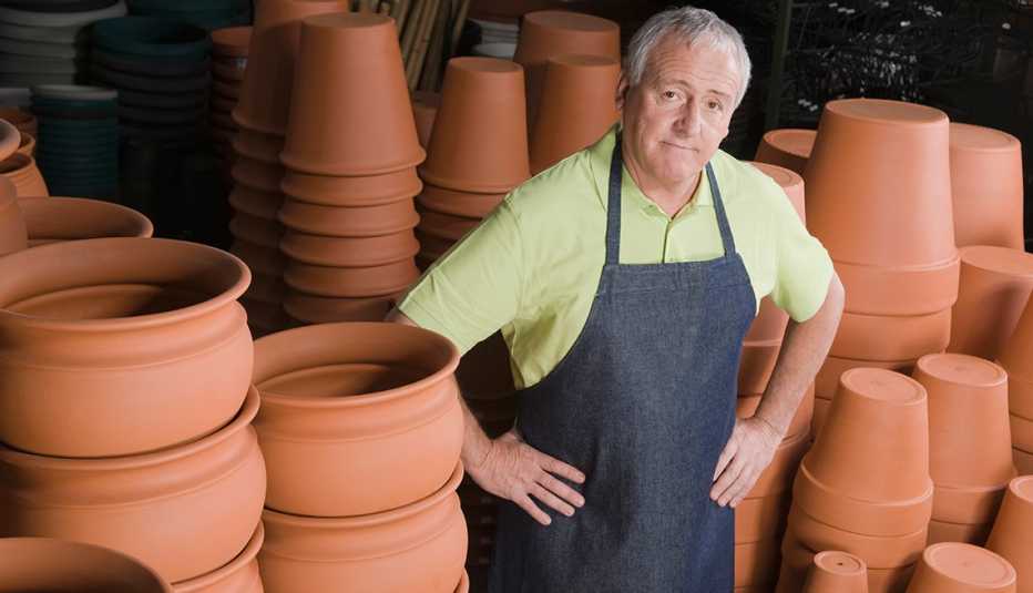 An older man standing next to flower pots