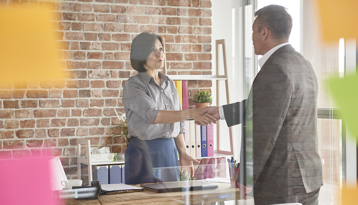 a man and woman shaking hands in an office